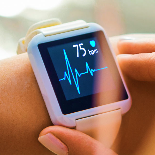 A person holding a smart watch with an ecg on it.