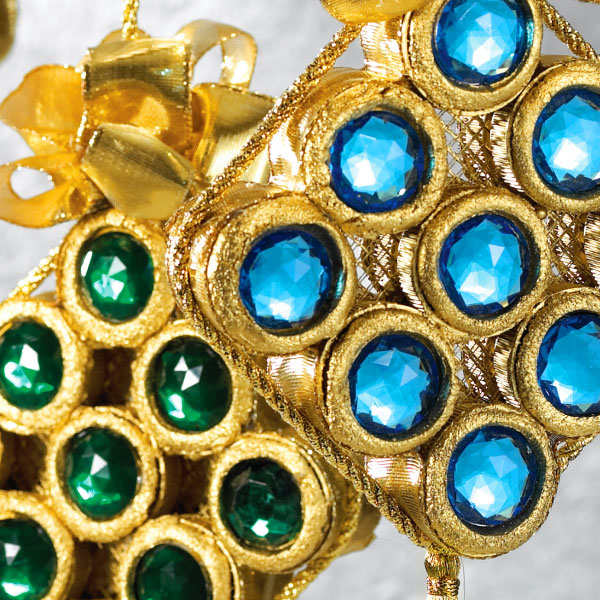 Decorative golden ornaments adorned with blue and green faux jewels.