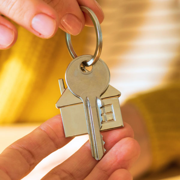 A person holding a key to a house.