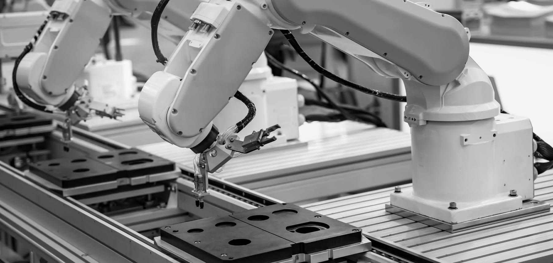 A black and white photo of robots in a factory.