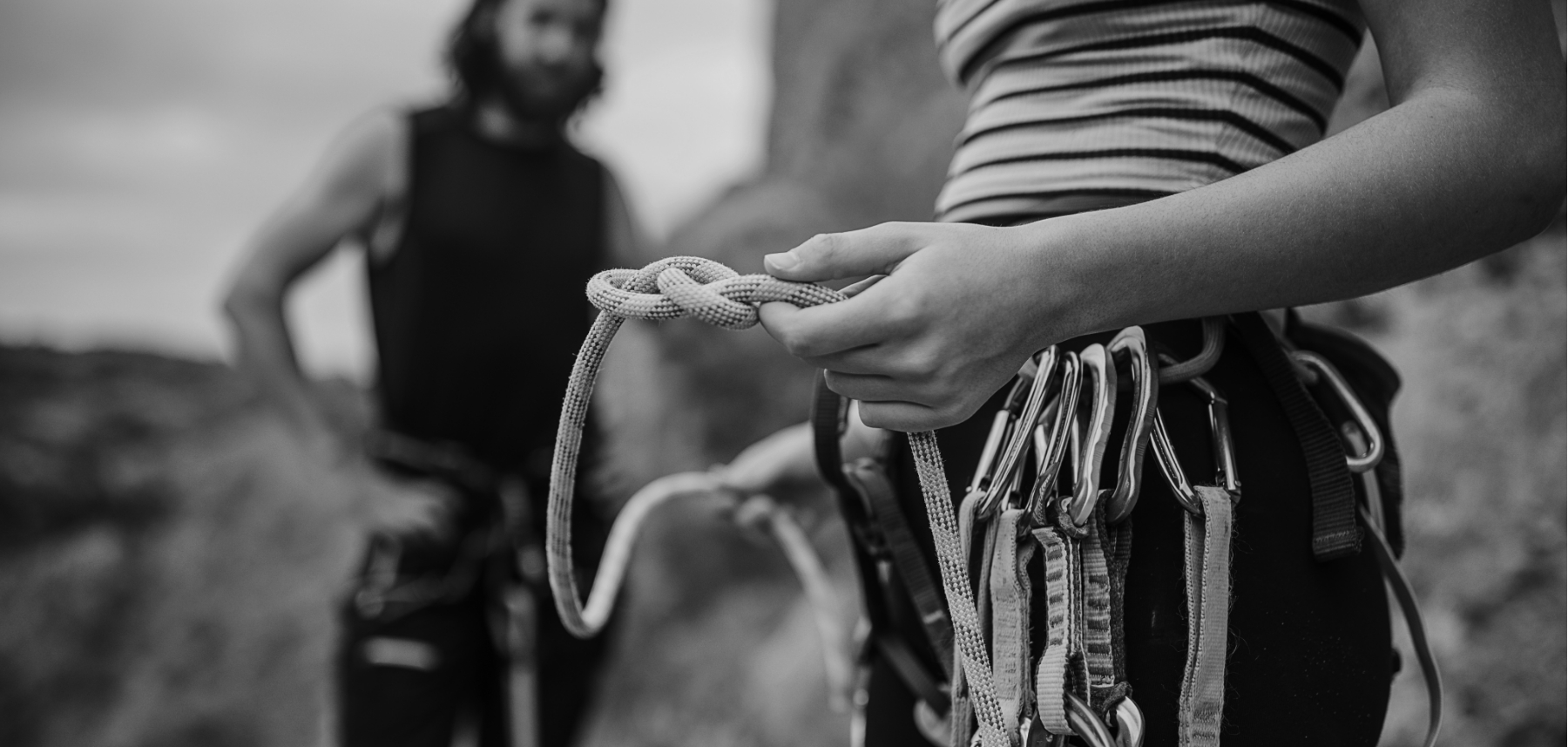 A black and white photo of two people holding ropes.